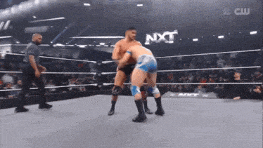 two men are wrestling in a ring with nxt written on the bottom