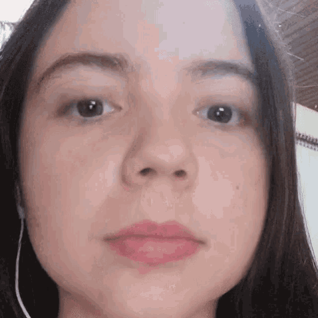 a close up of a woman 's face with headphones on her ears