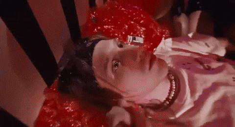 a woman is laying on the floor with blood coming out of her mouth .