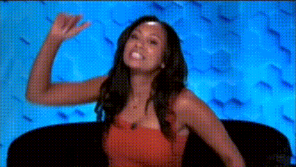 a woman is sitting on a couch and waving her hand .