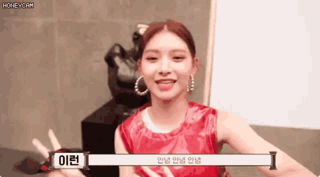 a woman in a red dress and hoop earrings is smiling and talking to someone .