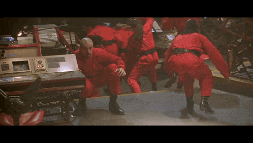 a group of people in red jumpsuits are standing around