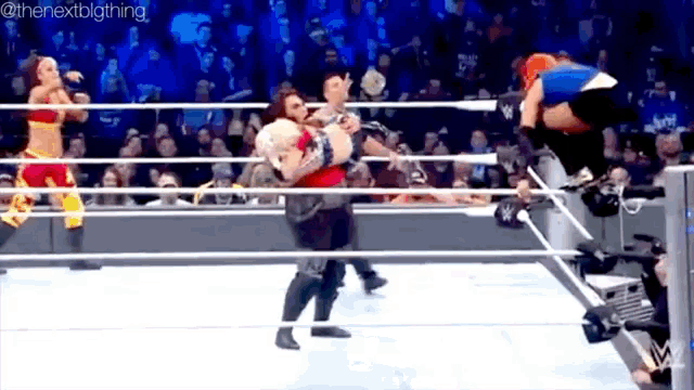 a group of people are wrestling in a ring .