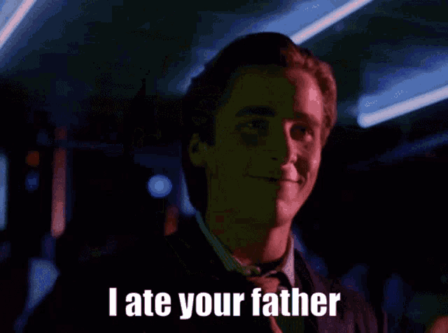 a man in a suit and tie is smiling and says " i ate your father "