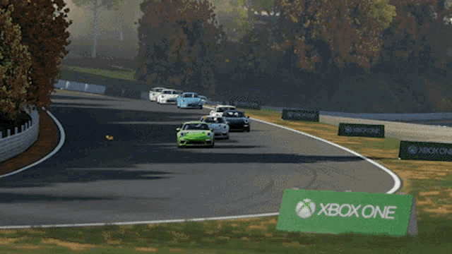 a group of cars are racing on a track and one of the cars is a green car