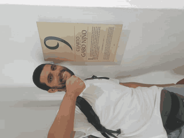 a man giving a thumbs up in front of a sign that says cuarto gabo nino