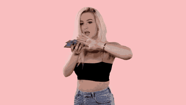 a woman is holding a pair of scissors in front of her face while condoms fall around her .