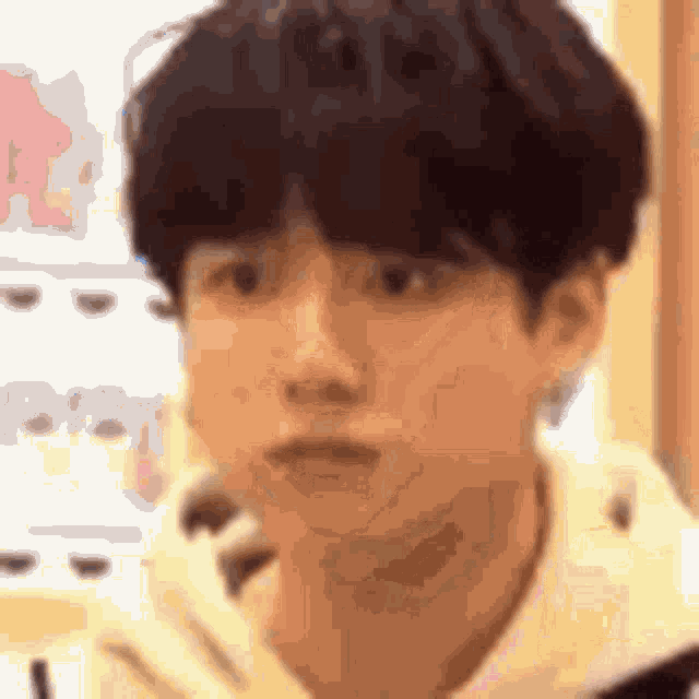 a close up of a person 's face with a blurry background and a hoodie on .
