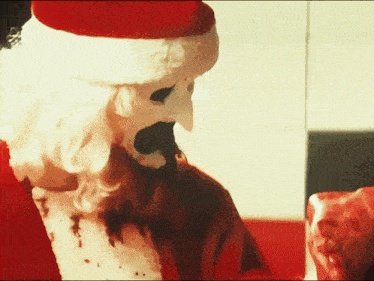 a man dressed as santa claus with a bloody face