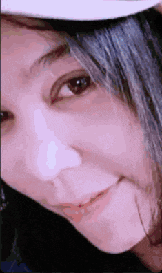 a close up of a woman 's face with a white hat on .