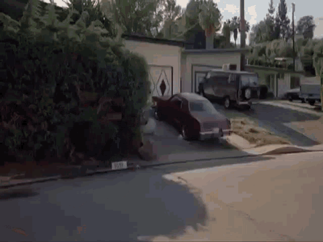 a red car is parked in front of a house with a license plate that says ' jc ' on it .