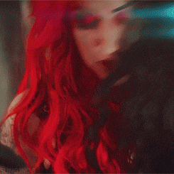 a woman with red hair is wearing a choker around her neck