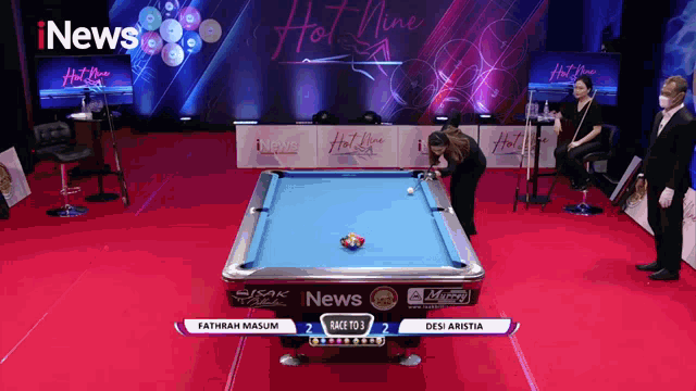 a pool table sponsored by inews is being played