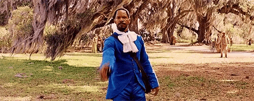 a man in a blue suit is standing in a park .