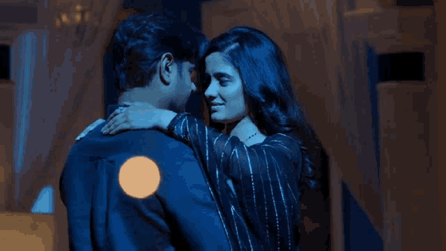 a man and a woman are hugging in the dark