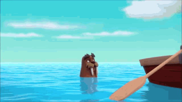 a walrus is swimming in the ocean with a boat in the background