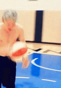 a shirtless man is playing basketball on a court