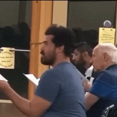 a man in a blue shirt is sitting in front of a sign that says no smoking