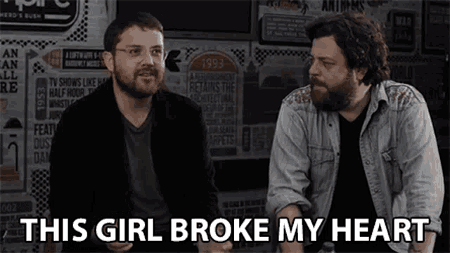 two bearded men are sitting next to each other and one of them is saying this girl broke my heart