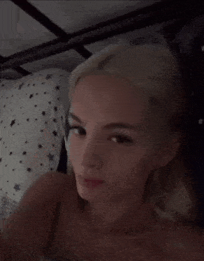 a woman laying in bed with her eyes closed and a pillow with stars on it