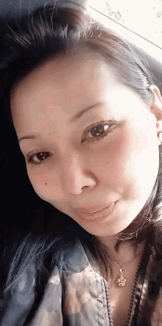 a close up of a woman 's face with a necklace