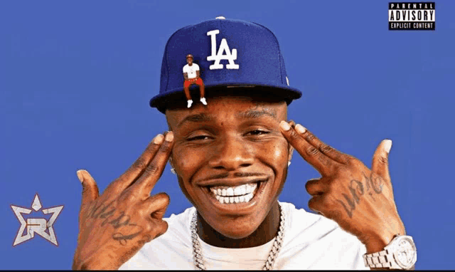 a man wearing a la hat is smiling with a parental advisory sticker behind him