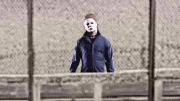 a man in a mask is standing behind a fence