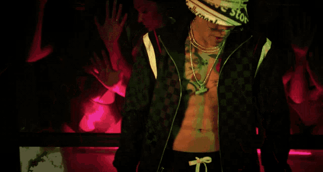 a man with a tattoo on his chest is standing in front of a group of people