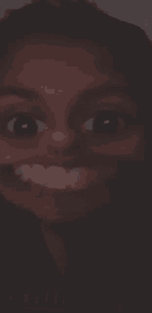 a close up of a woman 's face with a big smile