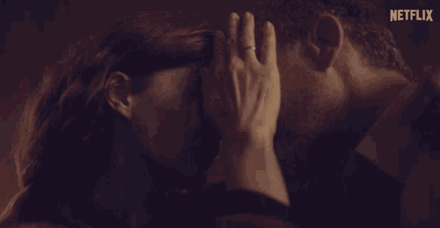 a close up of a man and woman kissing with a netflix logo in the background