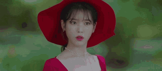 the woman is wearing a red hat and a red dress .