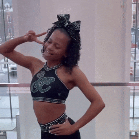 a cheerleader wearing a black crop top with the letter e on it