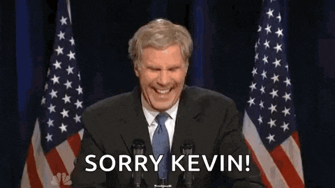 a man in a suit and tie is giving a speech in front of two american flags and saying `` sorry kevin '' .
