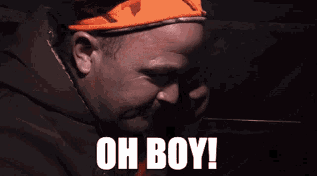 a man wearing an orange hat with the words oh boy written on it