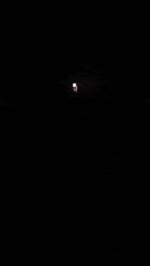 a woman 's face is displayed on a screen in the dark