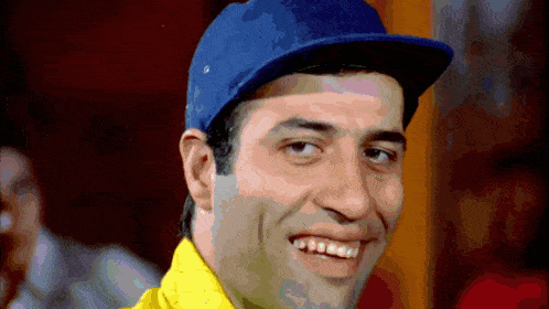 a man wearing a blue baseball cap and a yellow shirt smiles