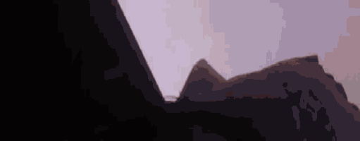 a silhouette of a mountain with a purple sky in the background