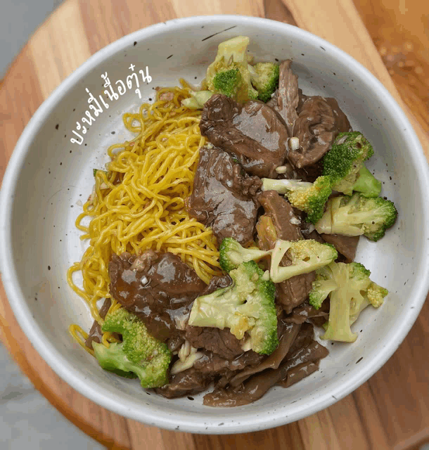 a bowl of beef and broccoli with noodles and sauce