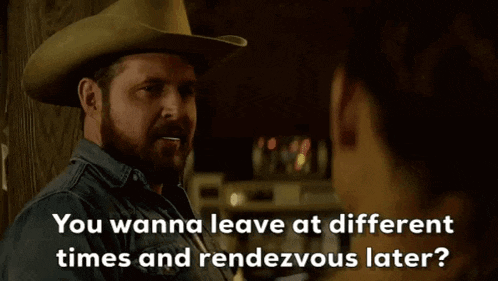 a man in a cowboy hat is talking to a woman in a dark room .