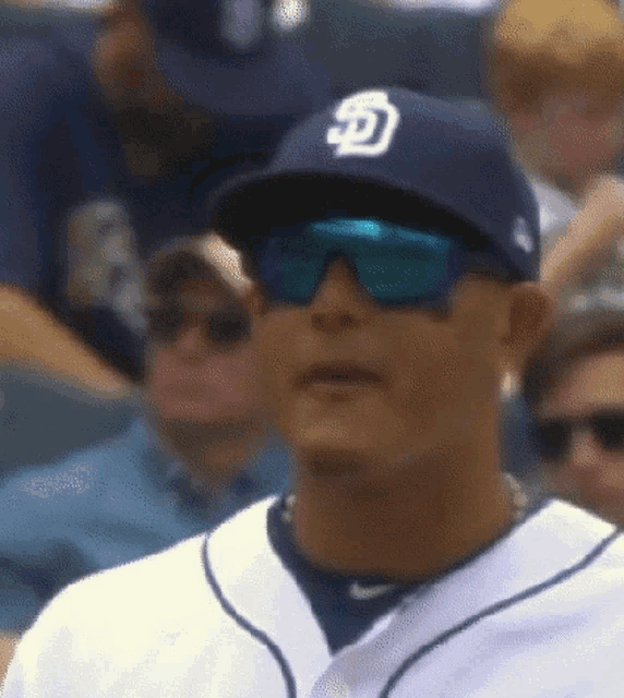 a close up of a baseball player wearing sunglasses and a hat with the letter s on it