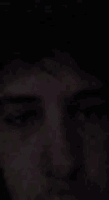 a close up of a person 's face in the dark .