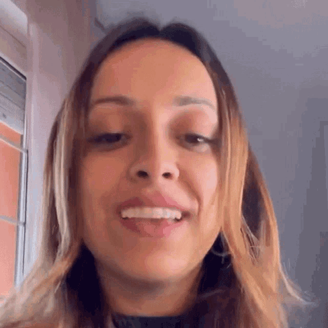 a woman is smiling and looking at the camera