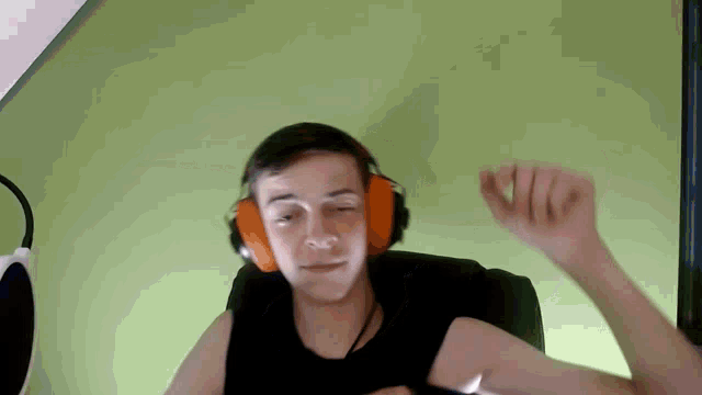 a young man wearing orange headphones is dancing
