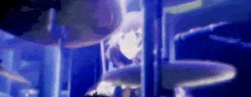 a blurry picture of a person standing in front of a slide in a water park .
