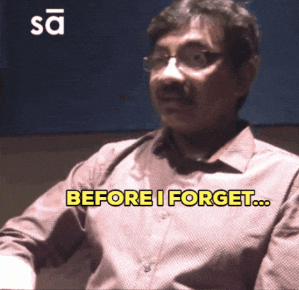 a man with glasses and a mustache says " before i forget "