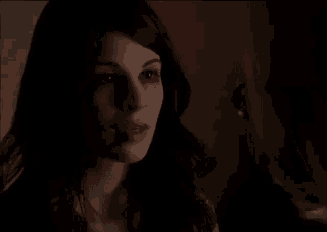 a woman with a bloody face is talking to a man in a dark room .