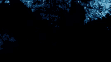 a man with a beard is standing in a dark cave .