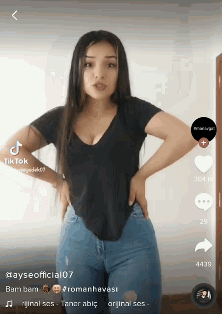 a woman in a black shirt and blue jeans is on a tik tok page