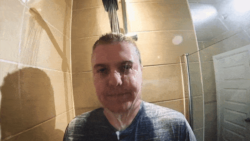 a man in a gray shirt is taking a shower