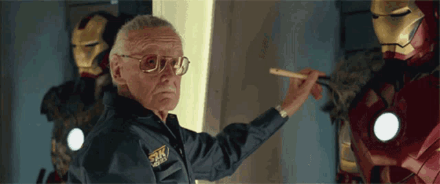 a man wearing a jacket that says stan lee on the front